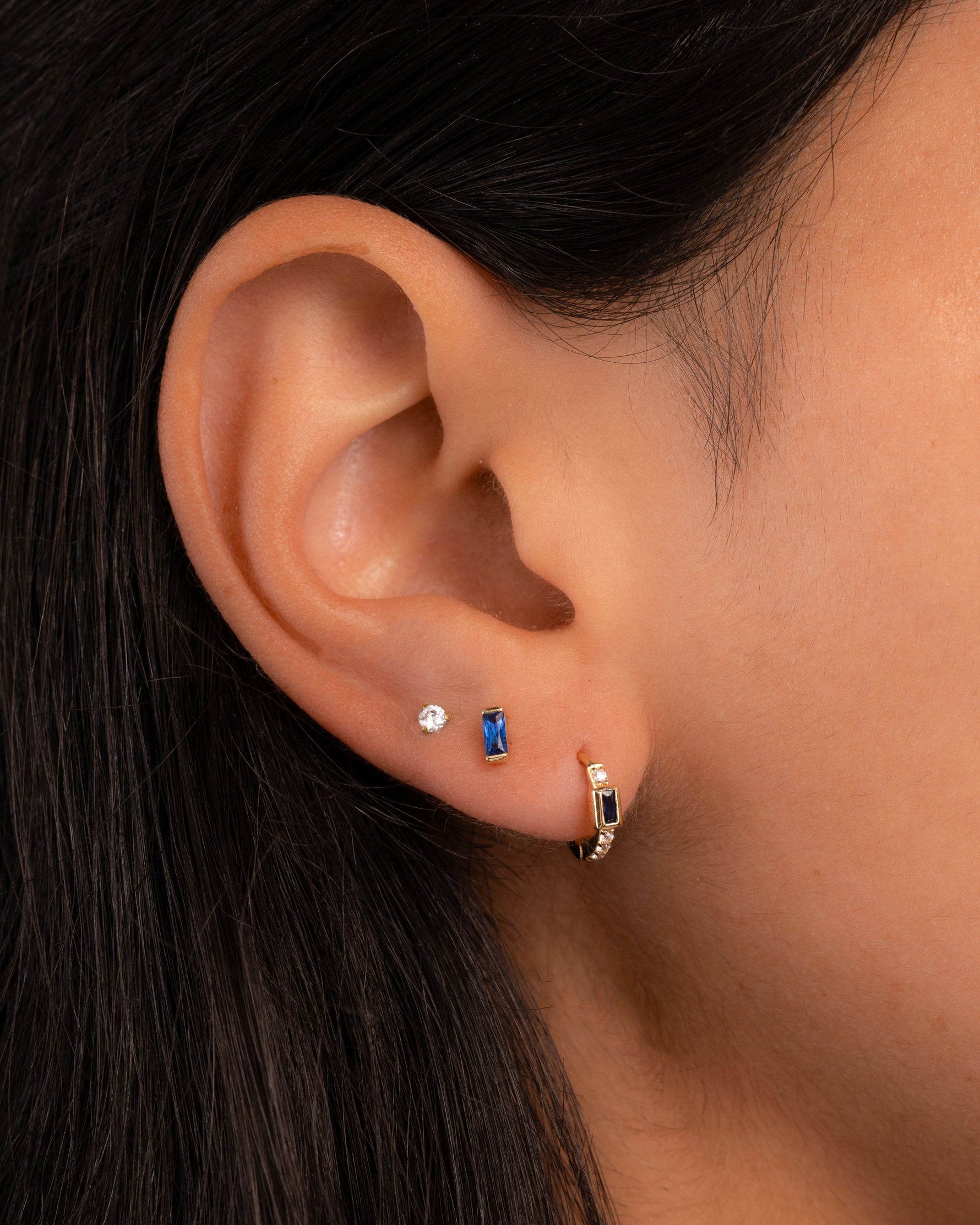 Gold sapphire baguette stud earrings by Sami Jewels featuring rectangular-cut blue sapphires set in classic gold settings.