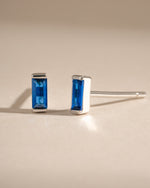 Sterling silver sapphire baguette stud earrings featuring rectangular-cut blue sapphires set in a sleek, elegant design.