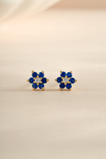 Gold sapphire flower stud earrings with CZ center stone by Sami Jewels, close-up view showing detailed floral design.