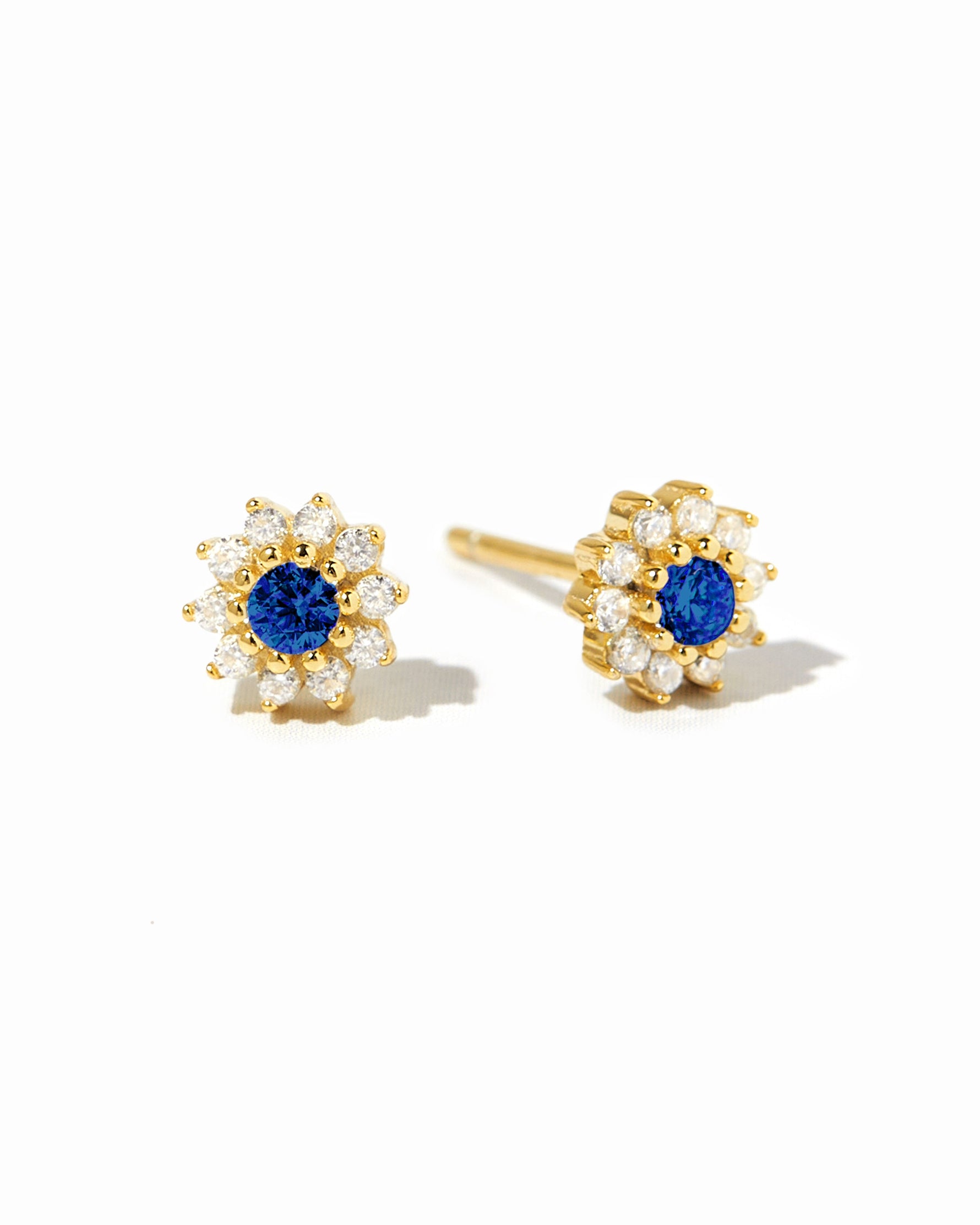 Sami Jewels sapphire dainty flower stud earrings with gold settings, displayed on a white background.
