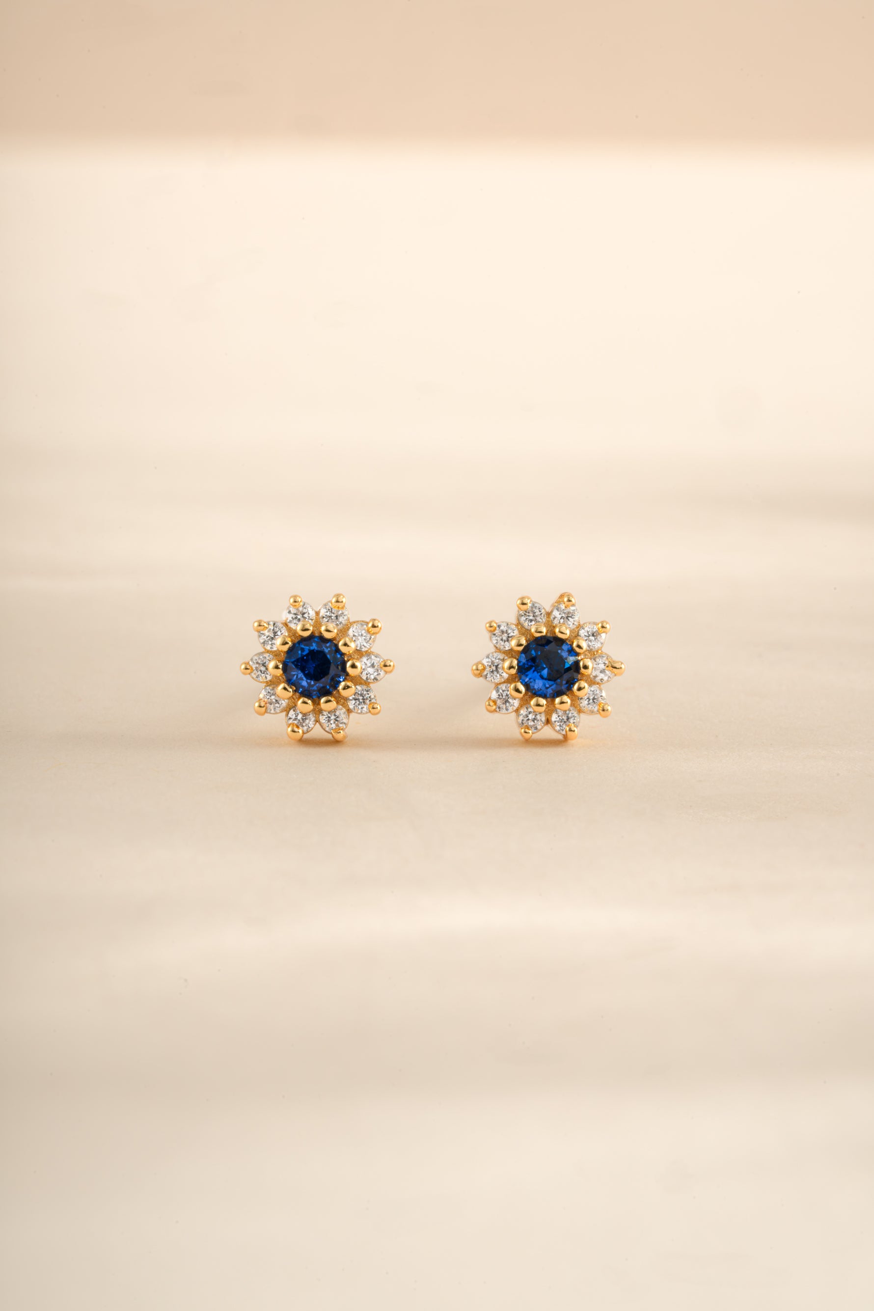 Gold sapphire dainty flower stud earrings by Sami Jewels featuring small, elegant gemstone floral design.
