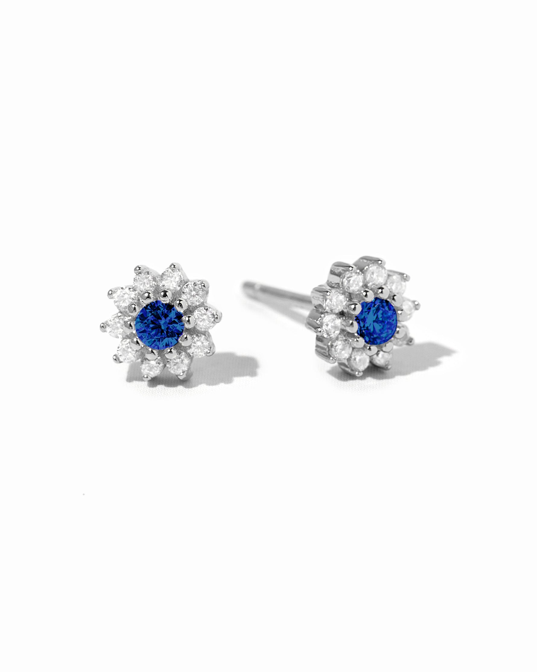 Sapphire dainty flower stud earrings by Sami Jewels featuring sterling silver and white background.