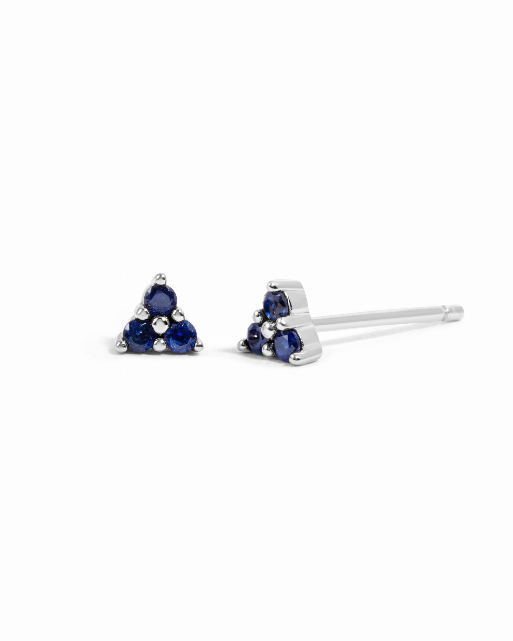 Sami Jewels tiny sapphire three-stone sterling silver earrings with blue sapphires on a white background.