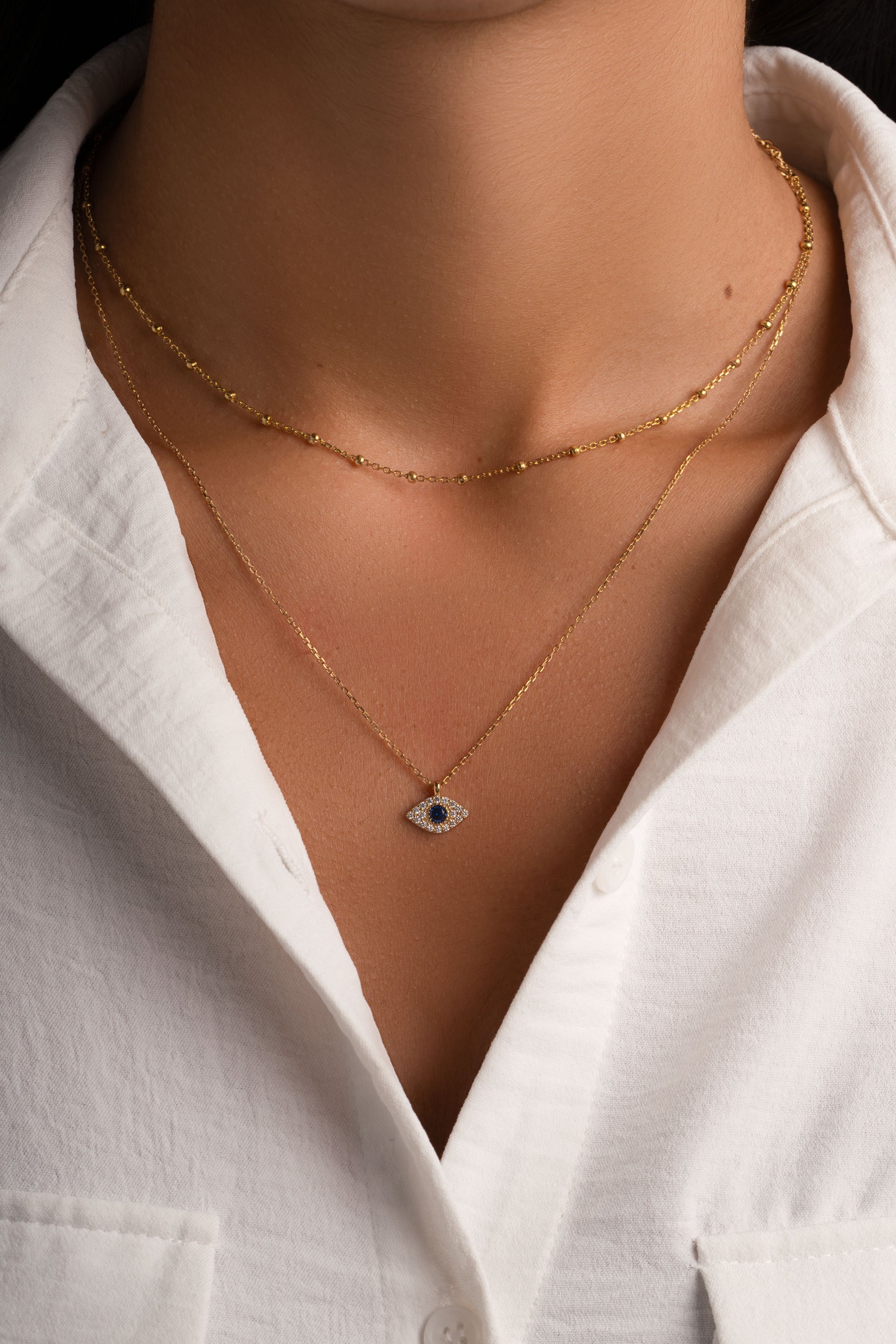 Gold sapphire evil eye necklace from Sami Jewels featuring a vibrant blue sapphire pendant on a delicate chain.