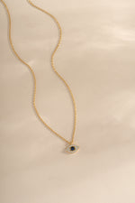 Gold sapphire evil eye necklace from Sami Jewels featuring a vibrant sapphire gemstone and protective evil eye charm.