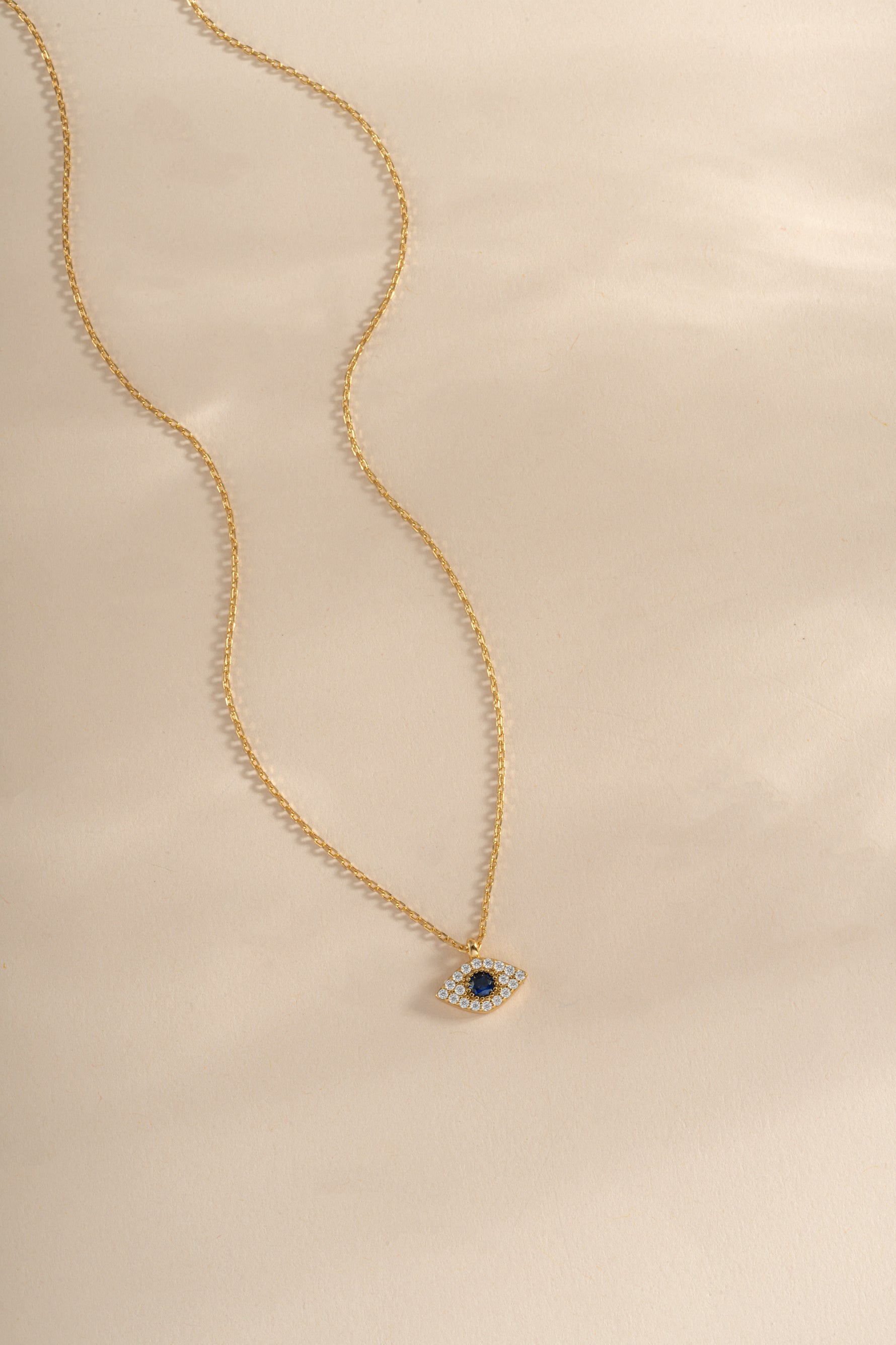 Gold sapphire evil eye necklace from Sami Jewels featuring a vibrant sapphire gemstone and protective evil eye charm.