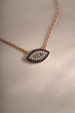 Close-up of Sami Jewels sapphire evil eye necklace in rose gold, showcasing its detailed design and vibrant blue gemstone.
