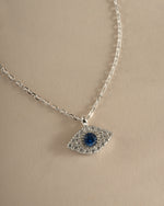 Close-up of Sami Jewels Sapphire Evil Eye Necklace featuring a sterling silver chain and vibrant sapphire evil eye pendant.