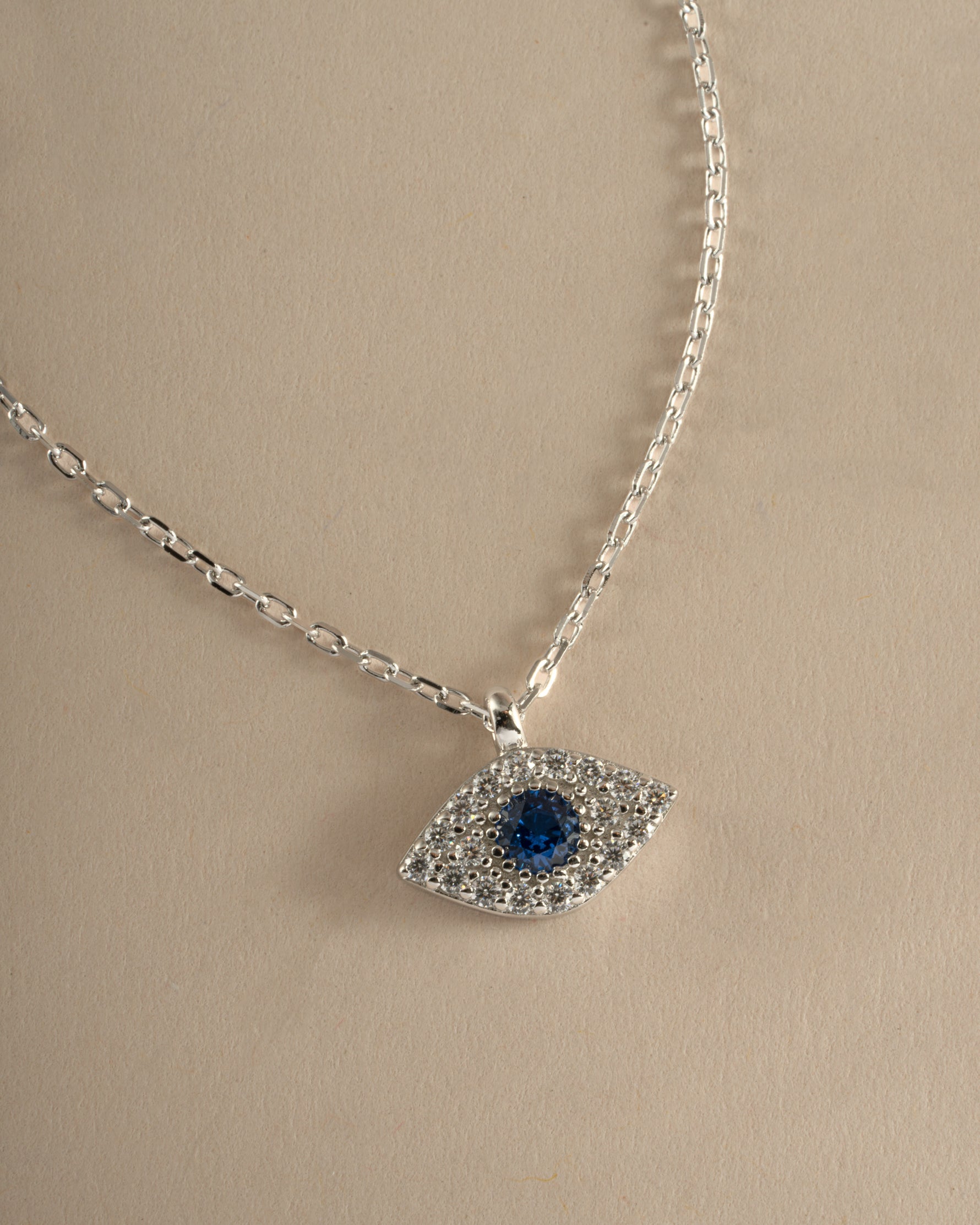 Close-up of Sami Jewels Sapphire Evil Eye Necklace featuring a sterling silver chain and vibrant sapphire evil eye pendant.
