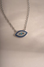 Sterling silver Sapphire Evil Eye Necklace featuring a vibrant blue sapphire charm, stylish and protective jewelry piece from Sami Jewels.