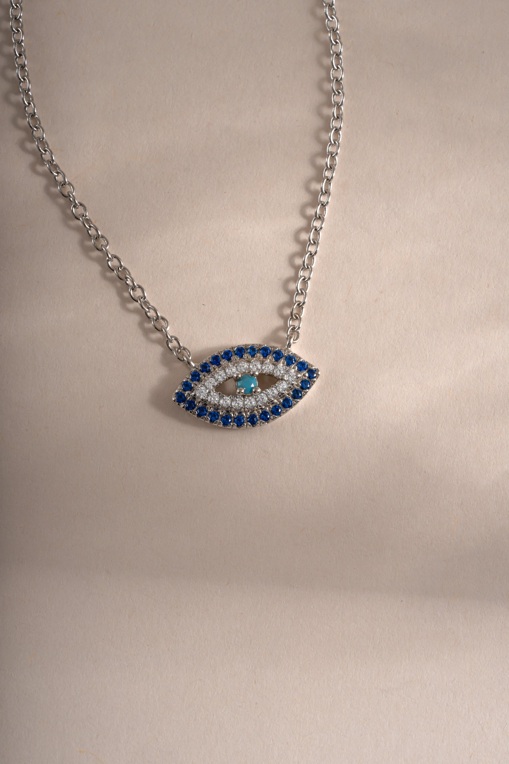 Sterling silver Sapphire Evil Eye Necklace featuring a vibrant blue sapphire charm, stylish and protective jewelry piece from Sami Jewels.