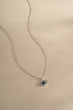 Sterling silver Sapphire Evil Eye Necklace featuring a blue gemstone pendant, designed by Sami Jewels.