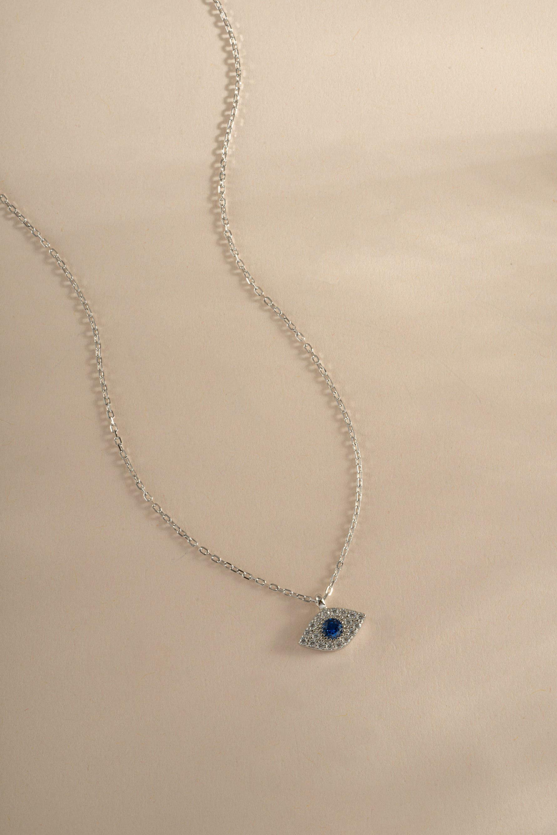Sterling silver Sapphire Evil Eye Necklace featuring a blue gemstone pendant, designed by Sami Jewels.