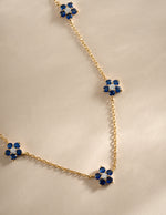 Close-up of SJ Faire Sapphire Flower Necklace featuring a gold chain and a detailed sapphire flower charm.