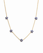 Gold sapphire flower necklace with a delicate charm, featuring a vibrant blue sapphire flower pendant on a fine chain.
