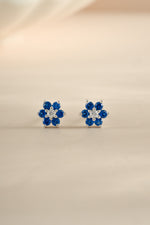 Sami Jewels sapphire flower stud earrings with CZ center stone in sterling silver, front view showing detailed floral design