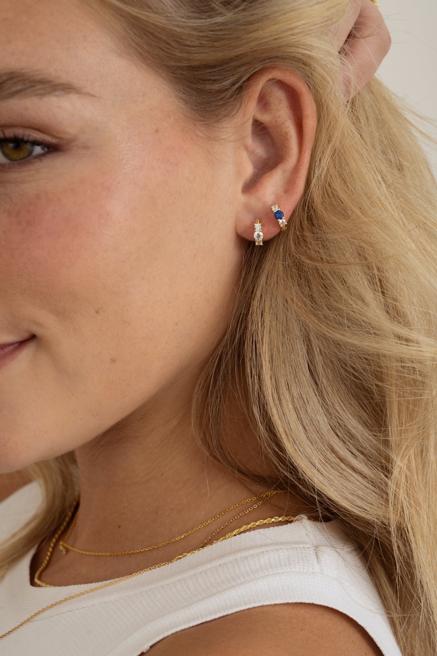 sapphire three stone huggie hoop earring on models ear