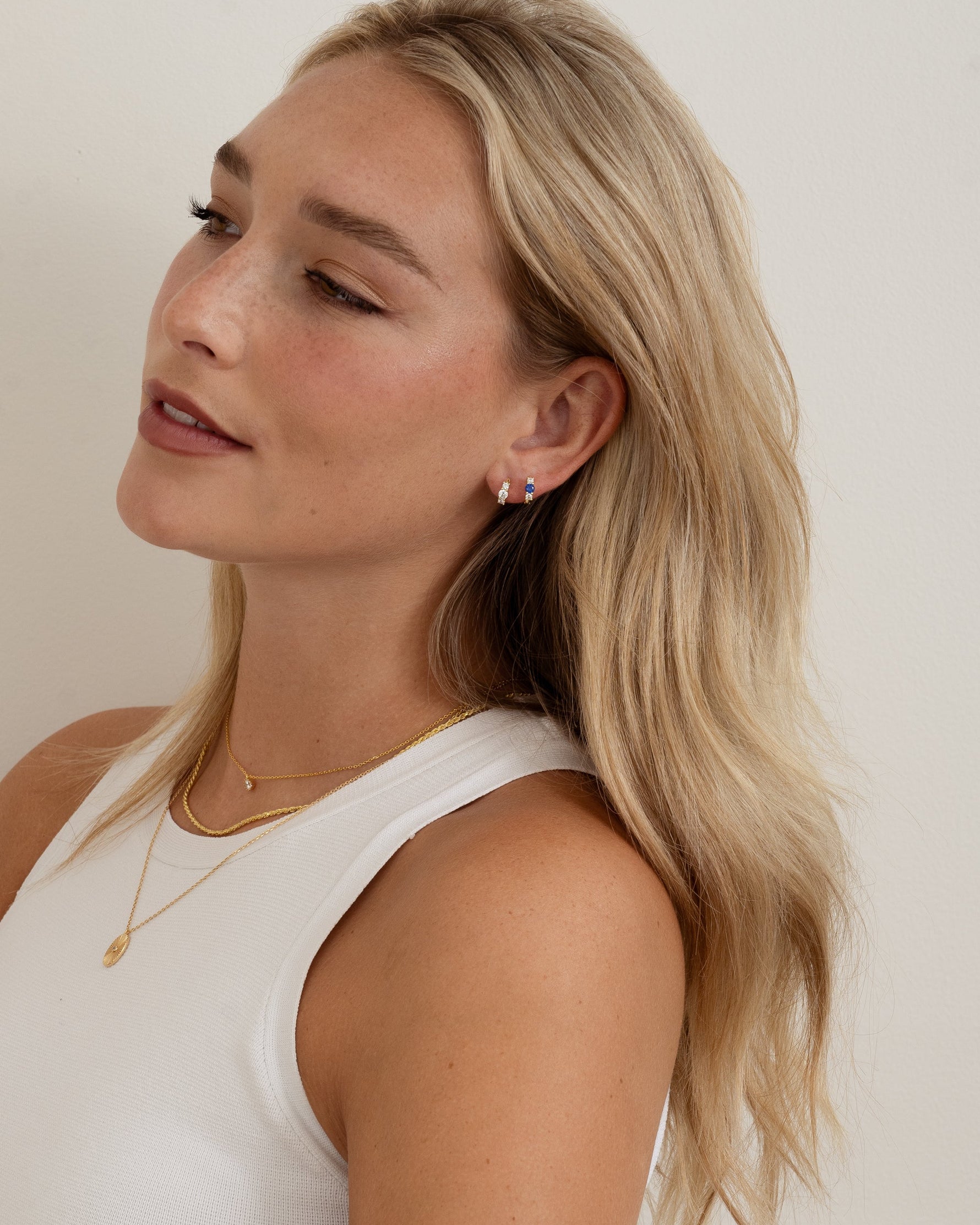 sapphire three stone huggie hoop earring on model