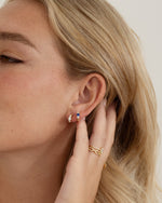 sapphire three stone huggie hoop earring gold closeup earring stack on model