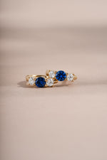 sapphire three stone huggie hoop earring gold closeup