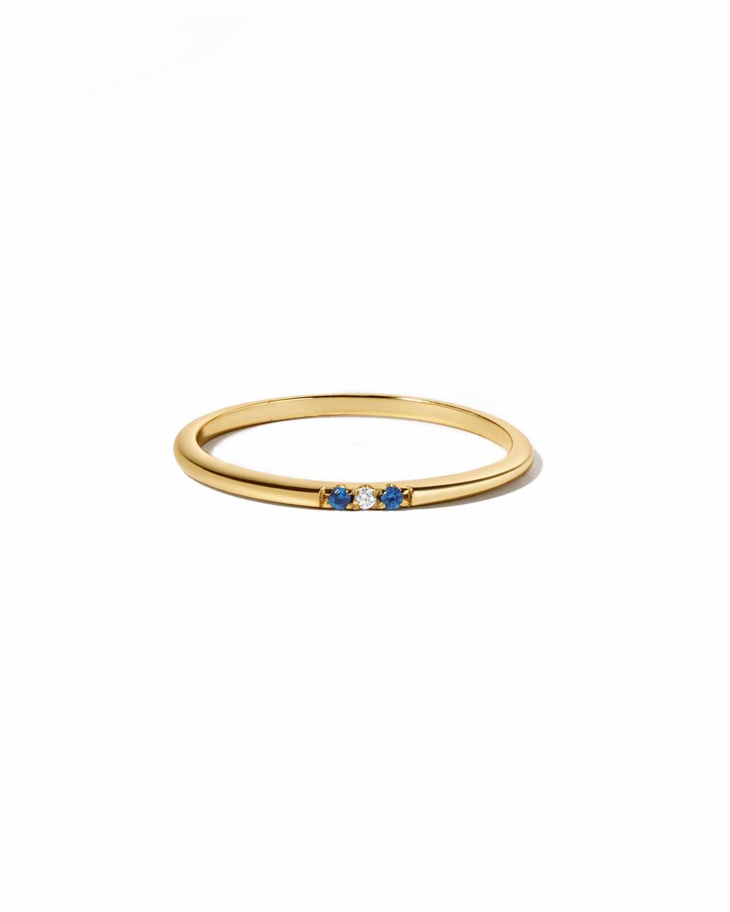 3 stone sapphire ring in gold on white background 