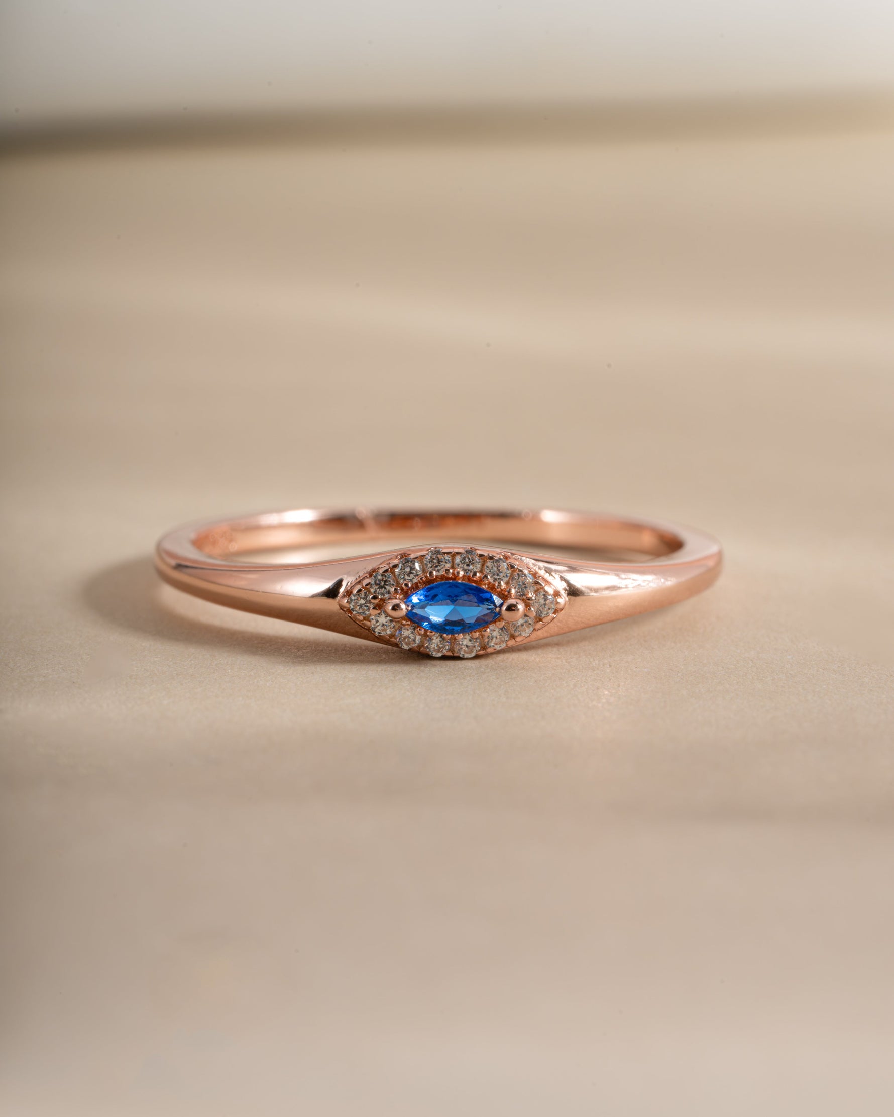 Close-up of Sami Jewels Sapphire Evil Eye Ring in rose gold, featuring a detailed sapphire gemstone and evil eye design.