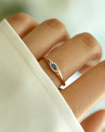 Sami Jewels sapphire evil eye ring with rose gold band, featuring a blue sapphire centerpiece and protective evil eye design.