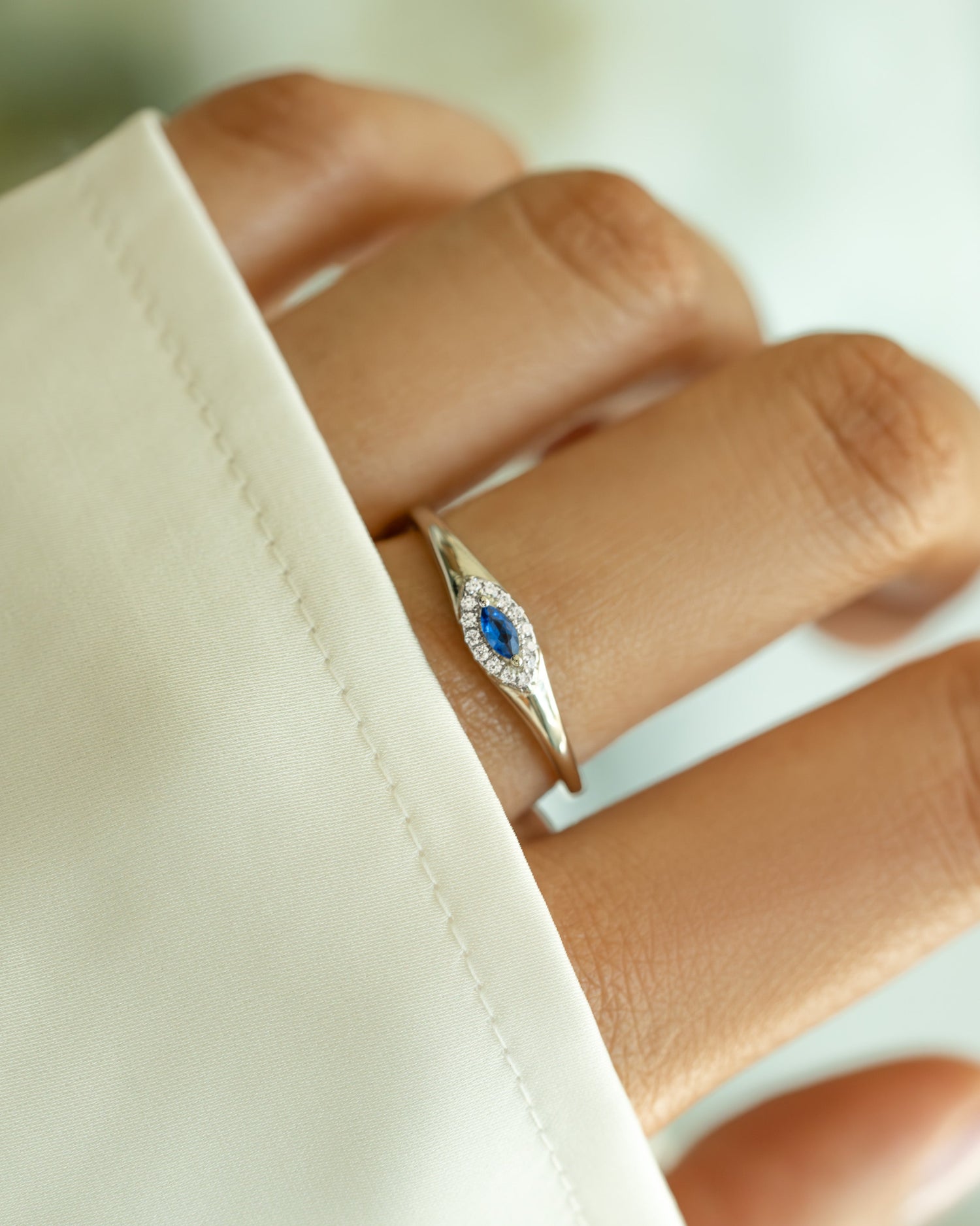 Sterling silver Sapphire Evil Eye Ring featuring a deep blue sapphire centerpiece and protective evil eye charm.