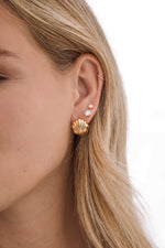 Stacked SS Shell Earrings by Sami Jewels featuring gold stainless steel shells on a model's ear. Water-resistant jewelry.