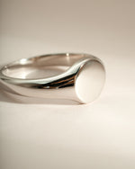 Close-up of a sterling silver signet ring from Sami Jewels featuring a polished, smooth surface and classic design.