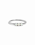 Silver ring with three opal stones on a white background