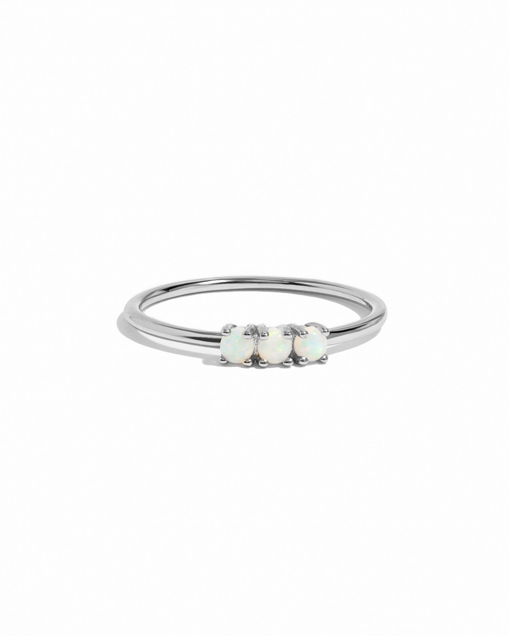 Silver ring with three opal stones on a white background