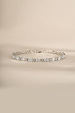 A silver tennis bracelet with clear oval and round cubic zirconia stones.