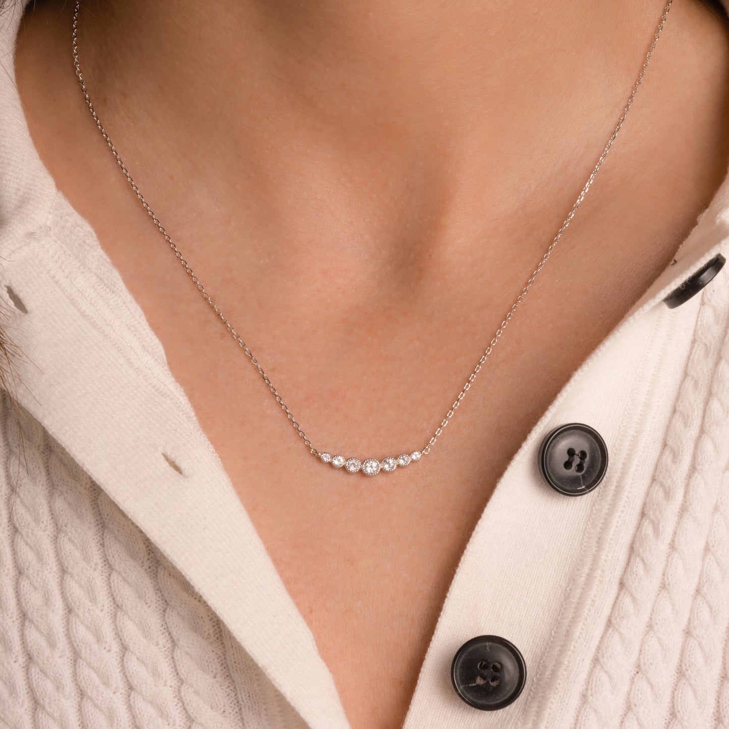 Sterling silver curved bar cz bezel necklace worn on female model.