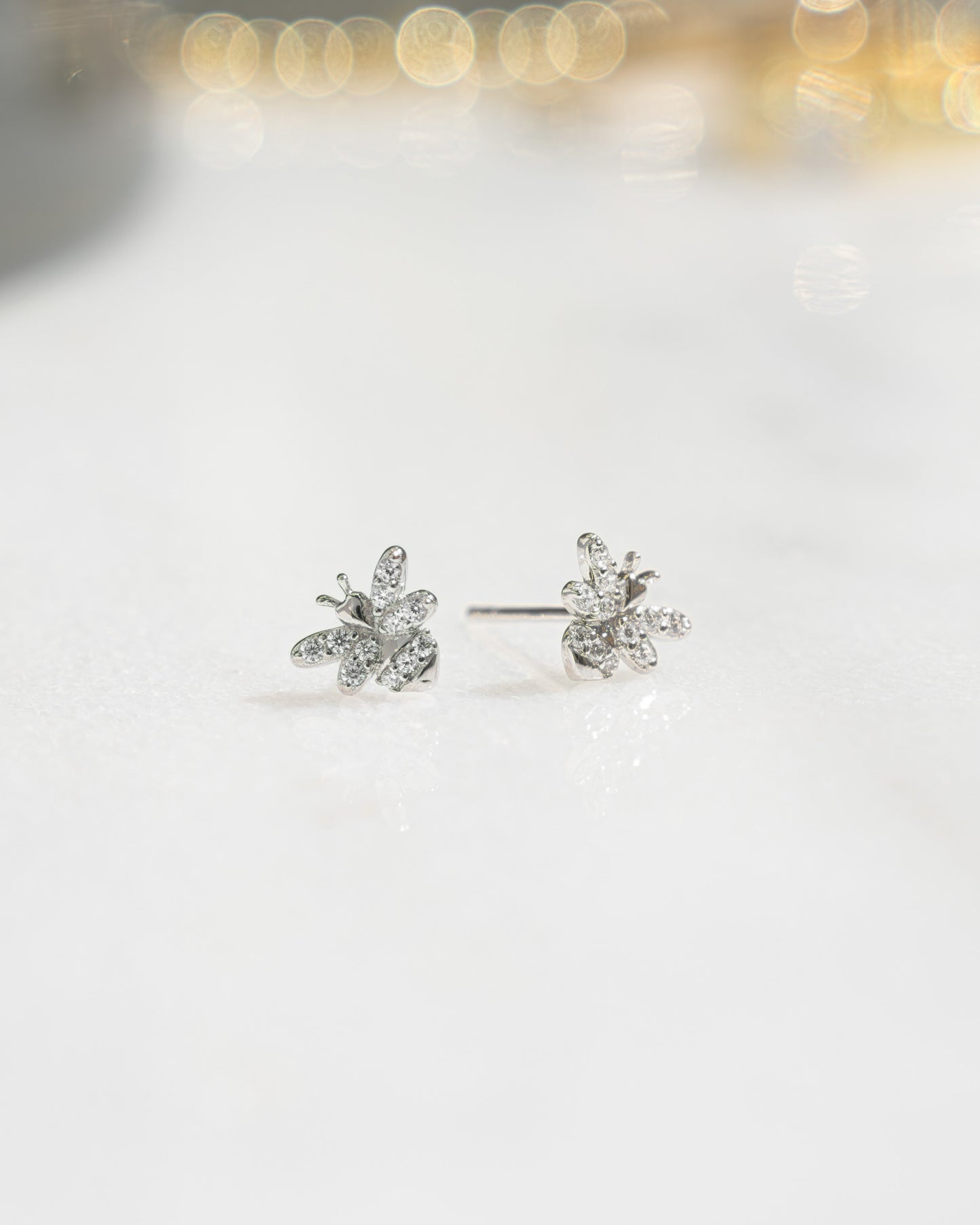 closeup image of silver diamond stud bee earrings