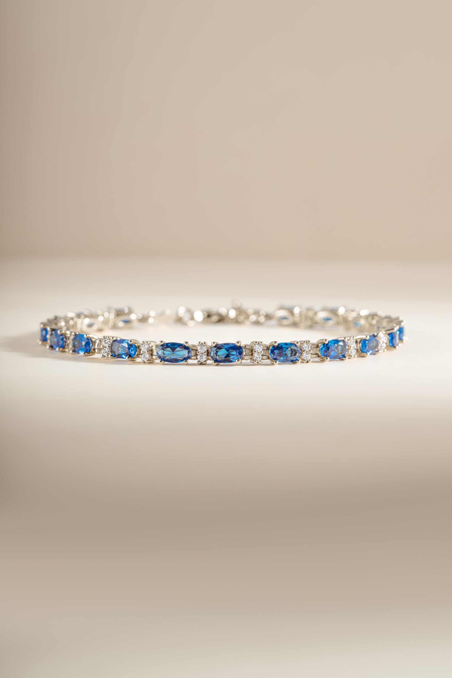 Silver oval sapphire bracelet with alternating round white stones. 