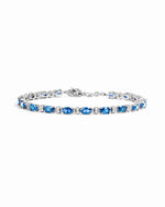 A silver bracelet featuring a row of oval-cut blue gemstones with alternating white round stones.