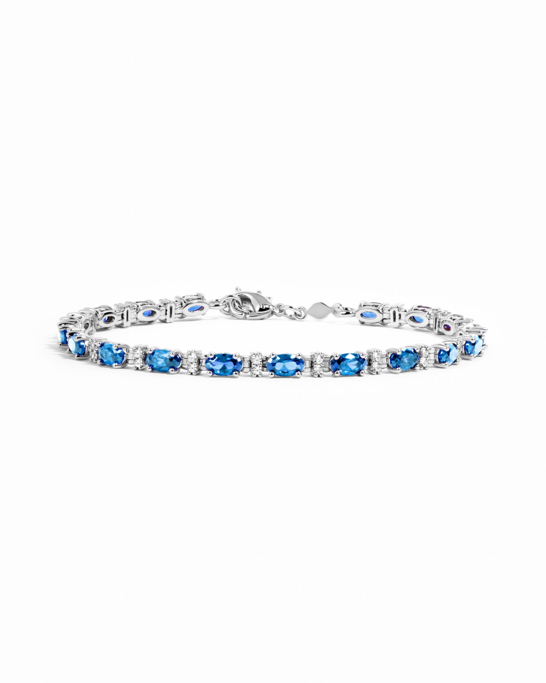 A silver bracelet featuring a row of oval-cut blue gemstones with alternating white round stones.