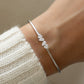 a woman's wrist wearing a silver cuff bracelet that is adjustable and made of cubic zirconia stones. 