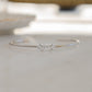 a close up of a dainty silver bracelet that is design to be adjustable and cuff design