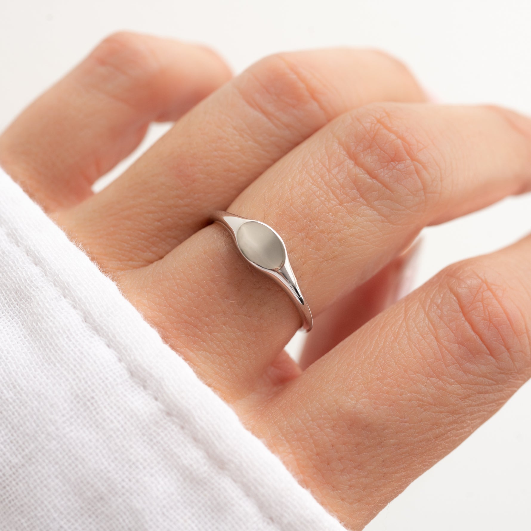 Dainty minimalist sterling silver signet ring on model.