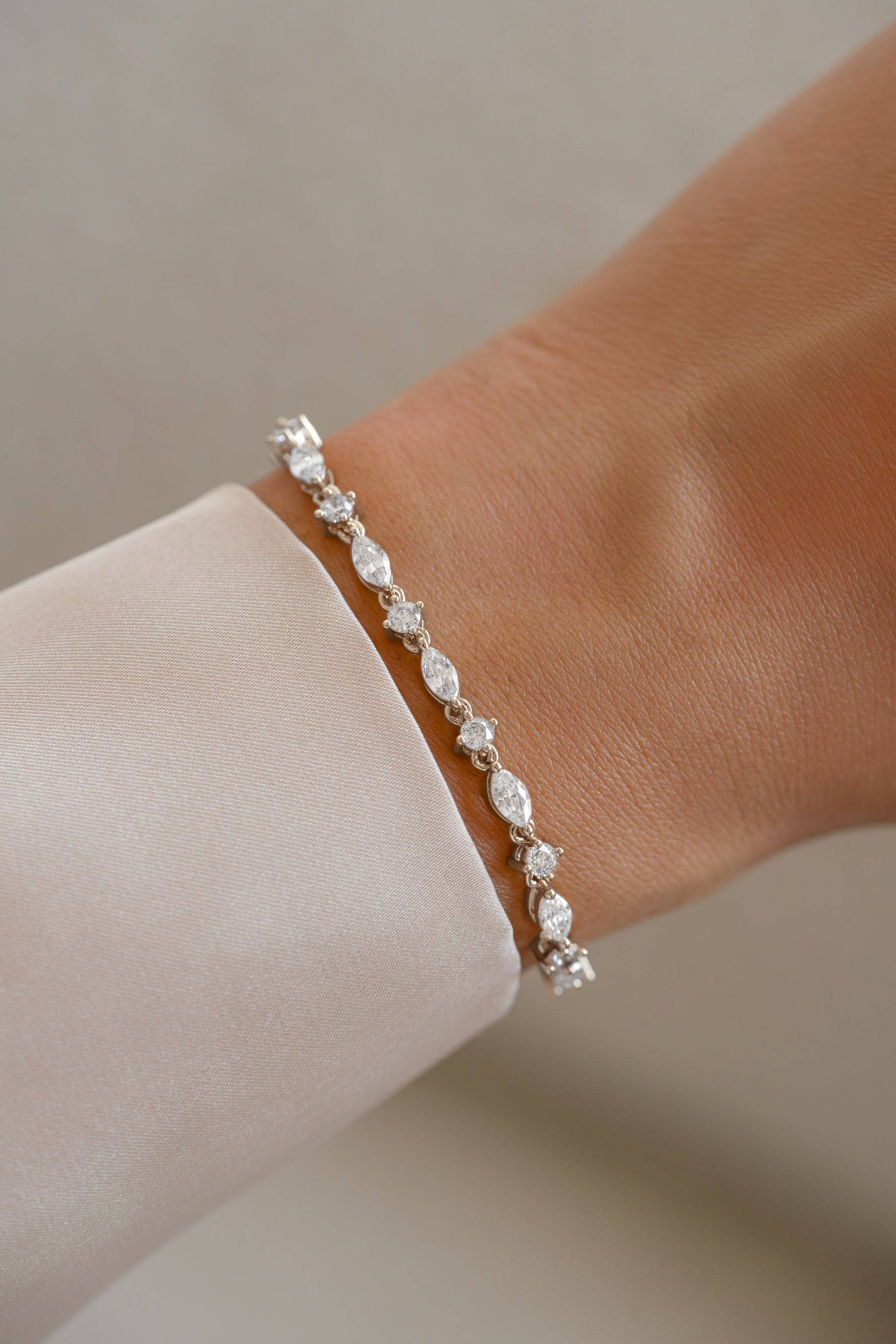 Silver diamond bracelet featuring marquise and round stones on wrist, by Sami Jewels.