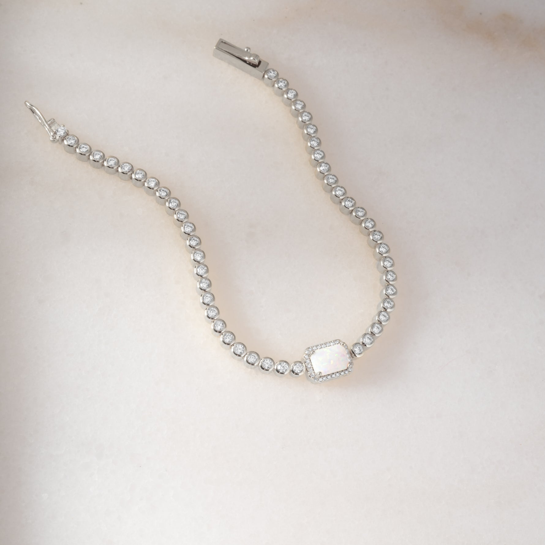 Silver Opal Baguette Tennis Bracelet by Sami Jewels featuring sparkling silver and opal baguette stones on a delicate bracelet.