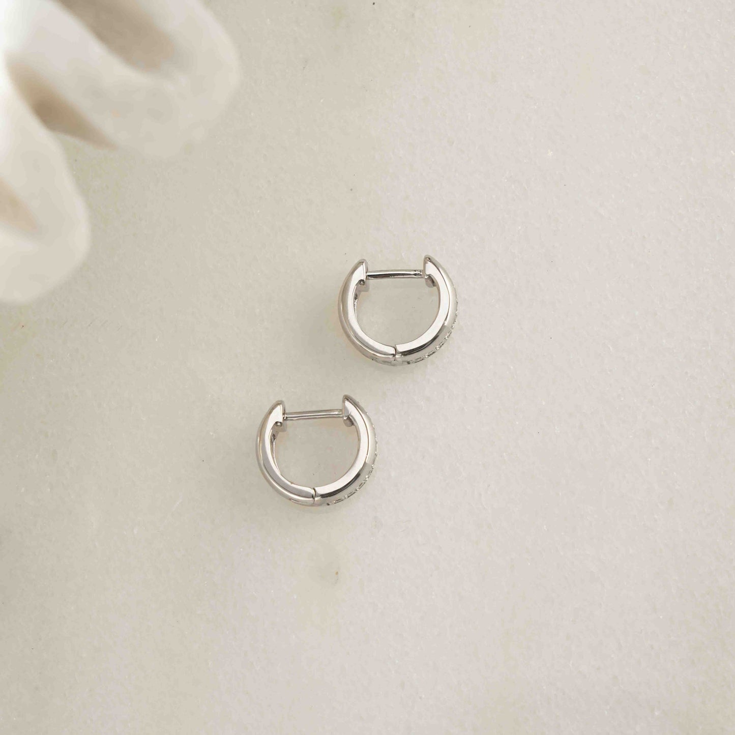 close up of minimalist silver hoop earrings