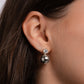 Model wearing small silver earrings with a ball and delicate diamond design.