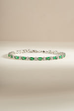 Silver tennis bracelet with oval green and round white cubic zirconia stones. 