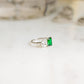 side profile of a sterling silver ring with emerald gemstone in a two stone ring design