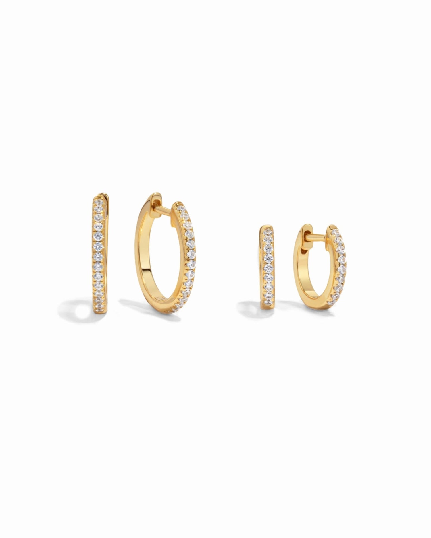 Close-up of small gold pave diamond earrings in two size options, highlighting delicate details.