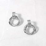flat lay of sterling silver hoop earrings, highlighting the fluid, curved knot detail.