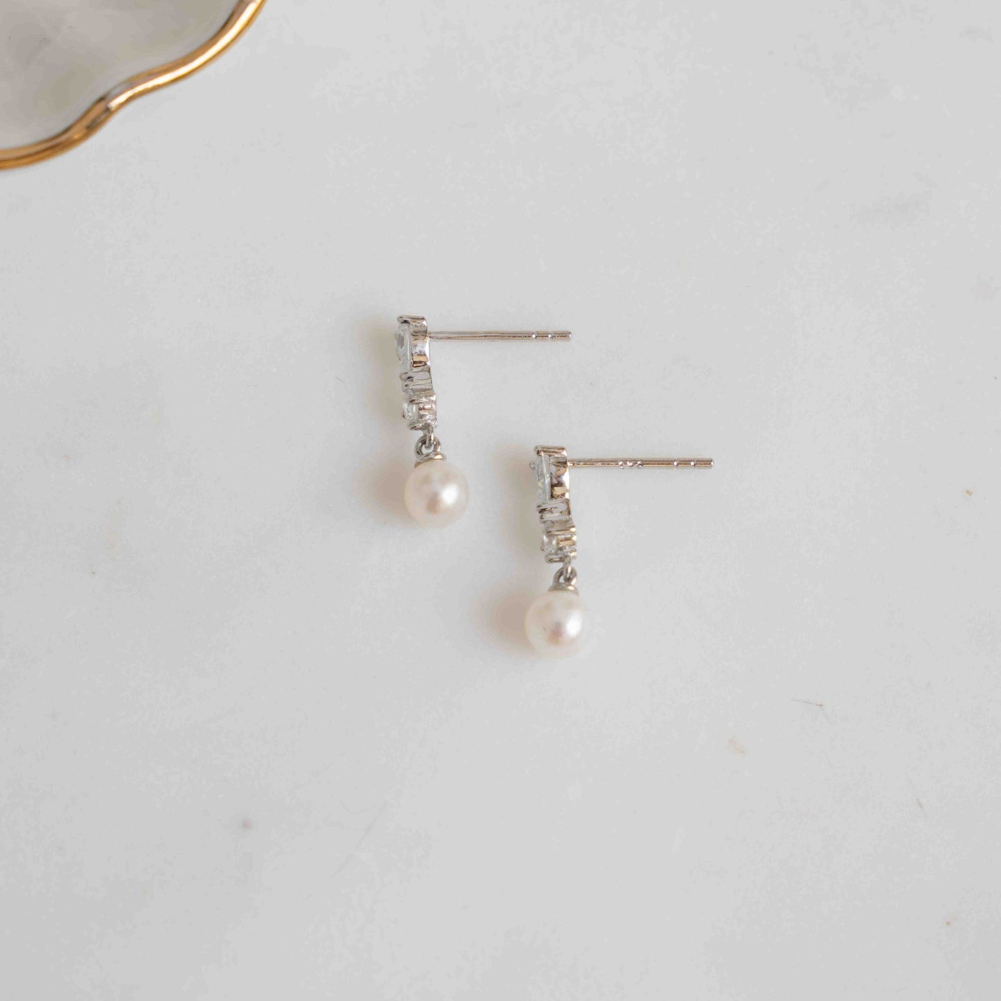 Silver pearl stud earrings on white background